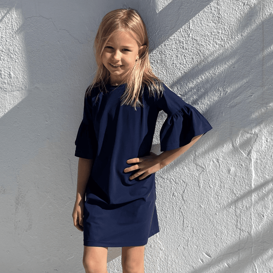 Young girl wearing a navy blue sun dress in Marbella